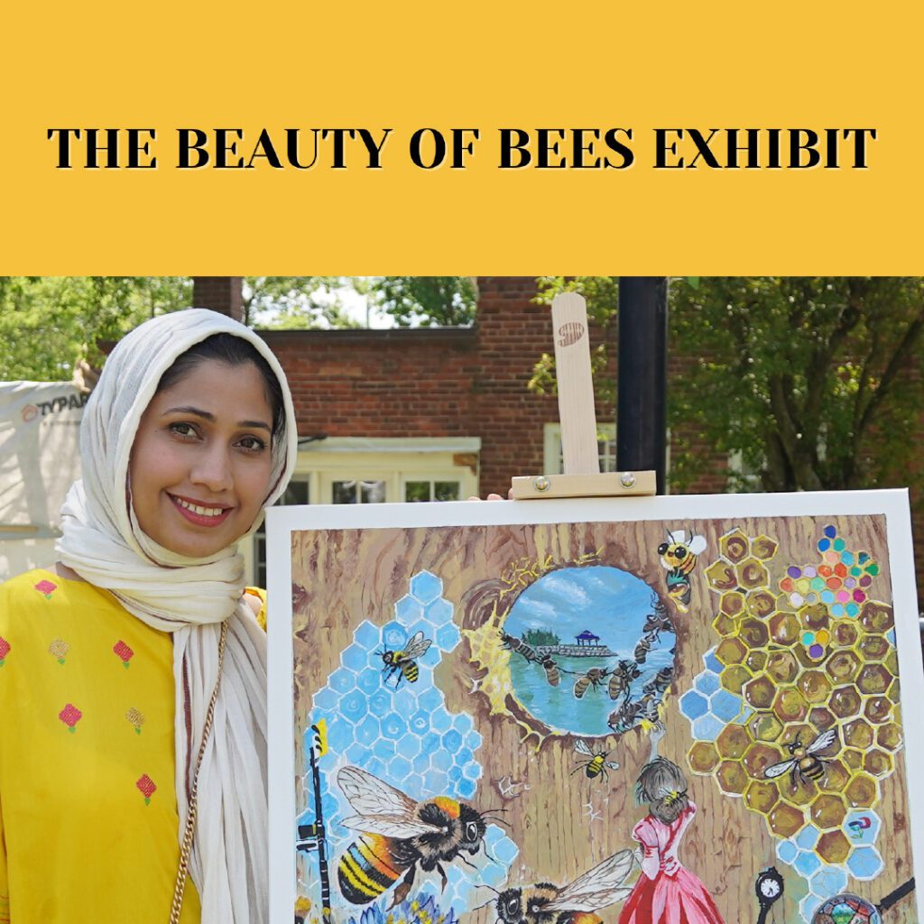 An artist wearing a bright yellow outfit and a headscarf holds a vibrant painting featuring bees, honeycomb patterns, and nature-inspired elements. The event title, "The Beauty of Bees Exhibit," is displayed in black text on a yellow background at the top.