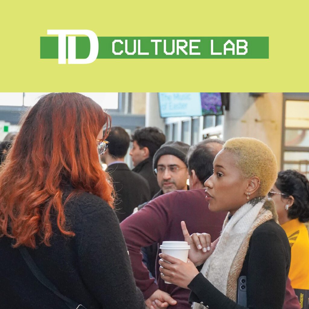 A lively networking event as part of TD Culture Lab, featuring diverse participants in conversation. Two women are seen talking, one holding a coffee cup, while a group of attendees mingles in the background.